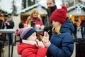 Adorable little sisters eating mini-donuts on traditional Christmas market. Royalty Free Stock Photo