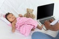 Adorable little sweet newborn baby girl lying on white bed near her mom using notebook laptop computer, cute infant with her busy Royalty Free Stock Photo