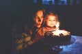 Adorable little toddler girl celebrating second birthday. Baby child daughter and young mother blowing candles on cake Royalty Free Stock Photo