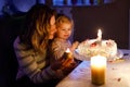 Adorable little toddler girl celebrating second birthday. Baby child daughter and young mother blowing candles on cake Royalty Free Stock Photo