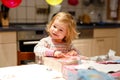 Adorable little toddler girl celebrating second birthday. Baby child unpacking gifts. Happy healthy child is suprised