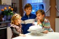 Adorable little toddler girl celebrating third birthday. Baby sister child and two kids boys brothers blowing together Royalty Free Stock Photo