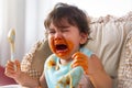 Adorable little toddler girl or infant baby crying when unsatisfied when finished eating food on baby chair. Cute infant girl get