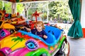 Adorable little toddler girl riding on funny car on roundabout carousel in amusement park. Happy healthy baby child Royalty Free Stock Photo