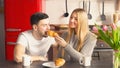 Adorable loving couple sharing breakfast together in kitchen