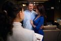 Adorable loving married couple in furniture design studio looking for new sofa. Blurred sales manager, interior designer with