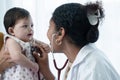 Adorable mixed race, Asian and Caucasian, newborn baby 3 months old girl check up examines by pediatrician. Doctor using Royalty Free Stock Photo