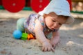 Adorable 9 months old baby playing outdoors - lifestyle portrait of mixed ethnicity Asian Caucasian baby girl playing with block Royalty Free Stock Photo