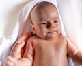 Adorable 2 months old little baby boy on towel after bath in his mother`s hands Royalty Free Stock Photo