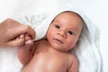 Adorable 2 months old little baby boy on towel after bath holding his mother`s hand Royalty Free Stock Photo