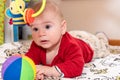 Adorable 6 months old little baby boy during tummy time surrounded by colourful toys Royalty Free Stock Photo