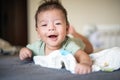 Adorable newborn baby boy lying on his tummy on the bed and smiling Royalty Free Stock Photo