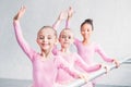 adorable multiethnic kids practicing ballet and smiling at camera Royalty Free Stock Photo