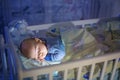 Adorable newborn baby boy, sleeping in crib at night Royalty Free Stock Photo