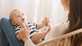 Adorable newborn baby cooing while lying on mother`s lap Royalty Free Stock Photo