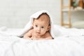 Adorable newborn baby lying on bed under white blanket Royalty Free Stock Photo