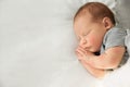 Adorable newborn baby peacefully sleeping on bed, top view