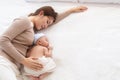 Adorable newborn baby sleeping on bed in mother arm nursing, young Asian beautiful mother lying down hold hug  infant 0-1 month Royalty Free Stock Photo