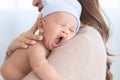 Adorable newborn baby yawn sleepy or cry on mom shoulder, young Asian beautiful mother hold infant 0-1 month with love, gently,