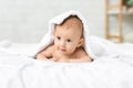 Adorable newborn boy lying on bed under soft white blanket Royalty Free Stock Photo