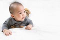 Adorable newborn kid during tummy time smiling happily at home.Portrait of cute smiling happy asian baby boy crawling on bed on Royalty Free Stock Photo