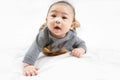 Adorable newborn kid during tummy time smiling happily at home.Portrait of cute smiling happy asian baby boy crawling on bed on Royalty Free Stock Photo