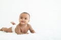 Adorable newborn Nigerian Asian baby girl wear diaper smiling with sparkling bright eyes and crawling on fluffy carpet on bed