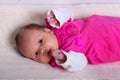 Adorable one month old baby girl in pink dress lies on a soft blanket Royalty Free Stock Photo