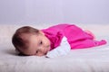 Adorable one month old baby girl in pink dress lies on a soft blanket Royalty Free Stock Photo