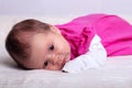 Adorable one month old baby girl in pink dress lies on a soft blanket Royalty Free Stock Photo