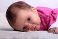 Adorable one month old baby girl in pink dress lies on a soft blanket Royalty Free Stock Photo