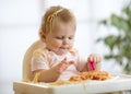 Adorable one-year baby try to catch a pasta