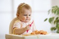 Adorable one-year baby try to catch a pasta