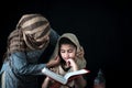 Adorable Pakistani girl with beautiful eyes wear hijab, learning Quran book with mother, Muslim family, daughter and mom read holy