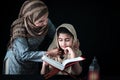 Adorable Pakistani girl with beautiful eyes wear hijab, learning Quran book with mother, Muslim family, daughter and mom read holy Royalty Free Stock Photo
