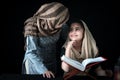 Adorable Pakistani girl with beautiful eyes wear hijab, learning Quran book with mother, Muslim family, daughter and mom read holy Royalty Free Stock Photo