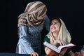 Adorable Pakistani girl with beautiful eyes wear hijab, learning Quran book with mother, Muslim family, daughter and mom read holy Royalty Free Stock Photo