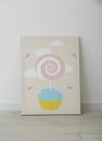 Adorable picture of cupcake and lollipop on floor near wall. Children`s room interior