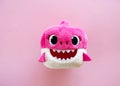 Adorable pink baby shark soft toy on pink background. Sweet childhood. Free copy space. Top view