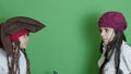 Adorable pirates, brothers in costumes making funny grimases, on green background