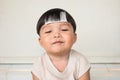 Adorable plump boy smilingly with chubby cheeked and close eyes. Front view of kid with illness