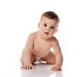 Adorable positive little baby girl infant in diaper try to creep on floor smiling and looking aside on white