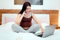 Adorable pregnant woman working and multitasking