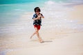 Adorable preschool children, boys, having fun on ocean beach. Excited children playing with waves, swimming, splashing happily