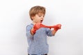 Adorable preschooler boy playing with a red slime