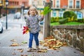 Adorable preschooler girl enjoying nice and sunny autumn day outdoors