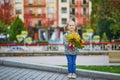 Adorable preschooler girl enjoying nice and sunny autumn day outdoors