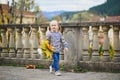 Adorable preschooler girl enjoying nice and sunny autumn day outdoors