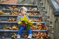 Adorable preschooler girl enjoying nice and sunny autumn day outdoors