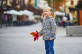 Adorable preschooler girl enjoying nice and sunny autumn day outdoors